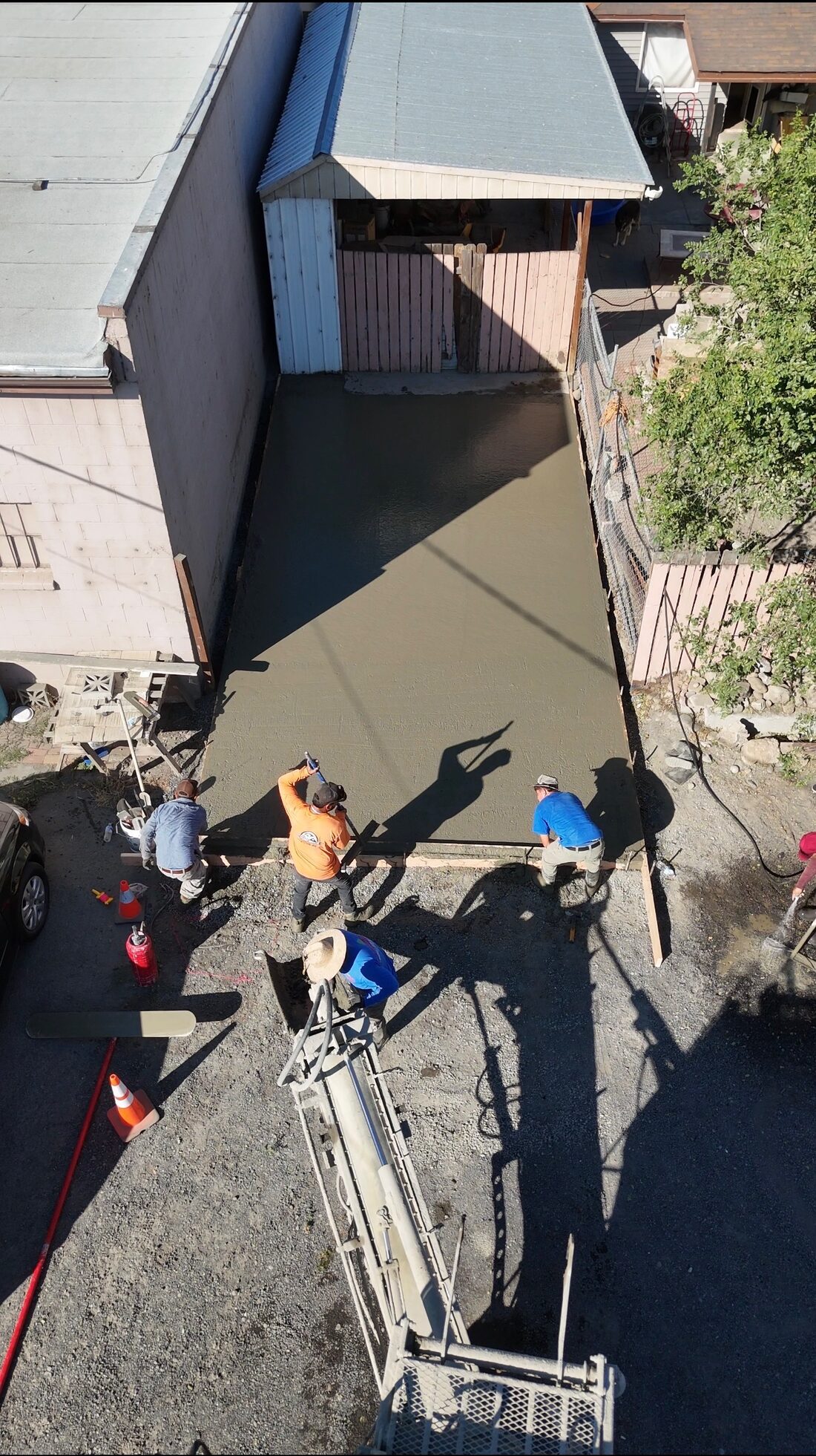 Crew pouring and screeding fresh concrete